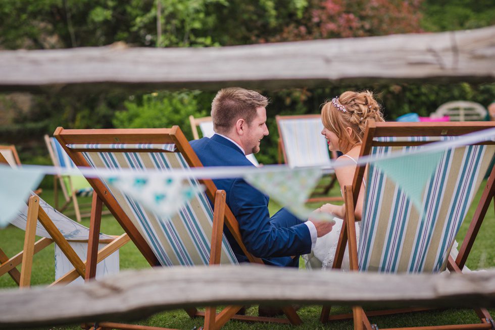 Bride and groom sitting on deck chairs during their Bartholomew Barn wedding