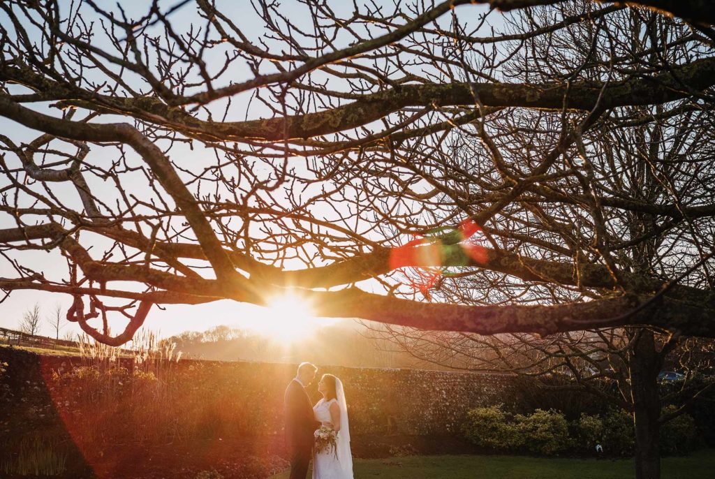 Bride and groom in the gardens of Pangdean Barn at golden hour
