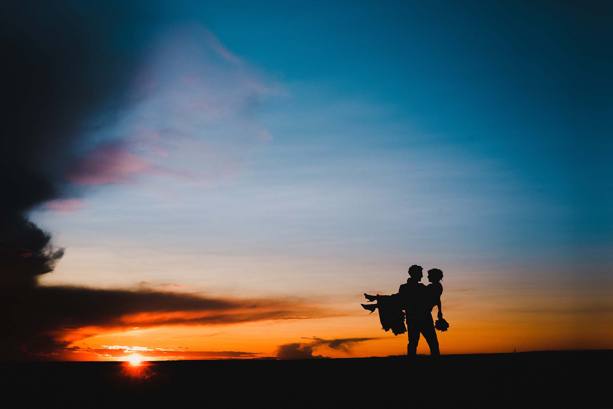 bride holding groom at sunset on the South Downs