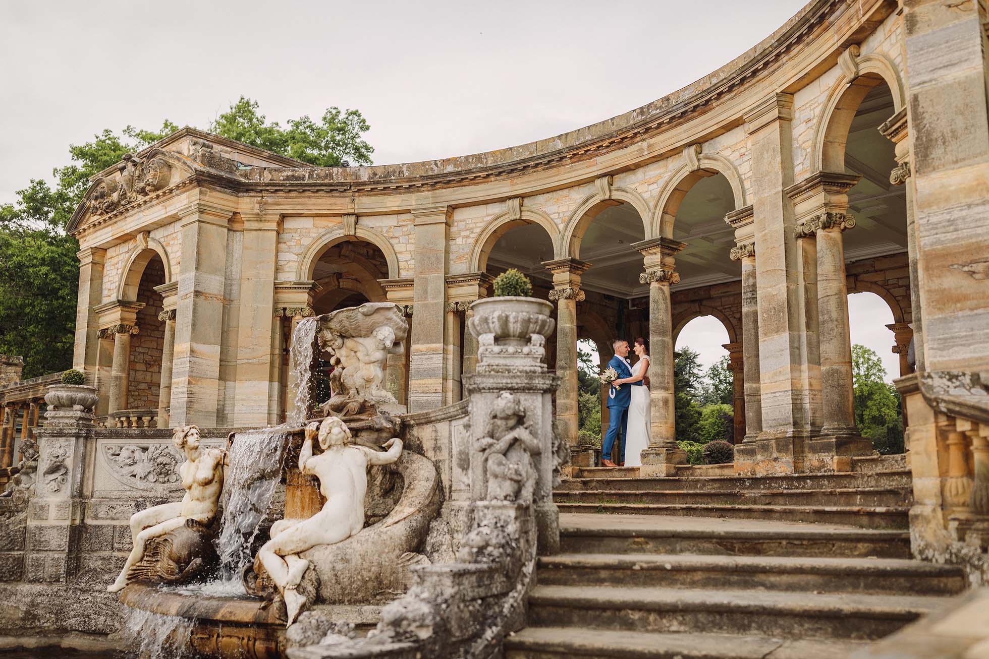 Bride and groom by the Nymph's fountain at the Hever Castle Loggia
