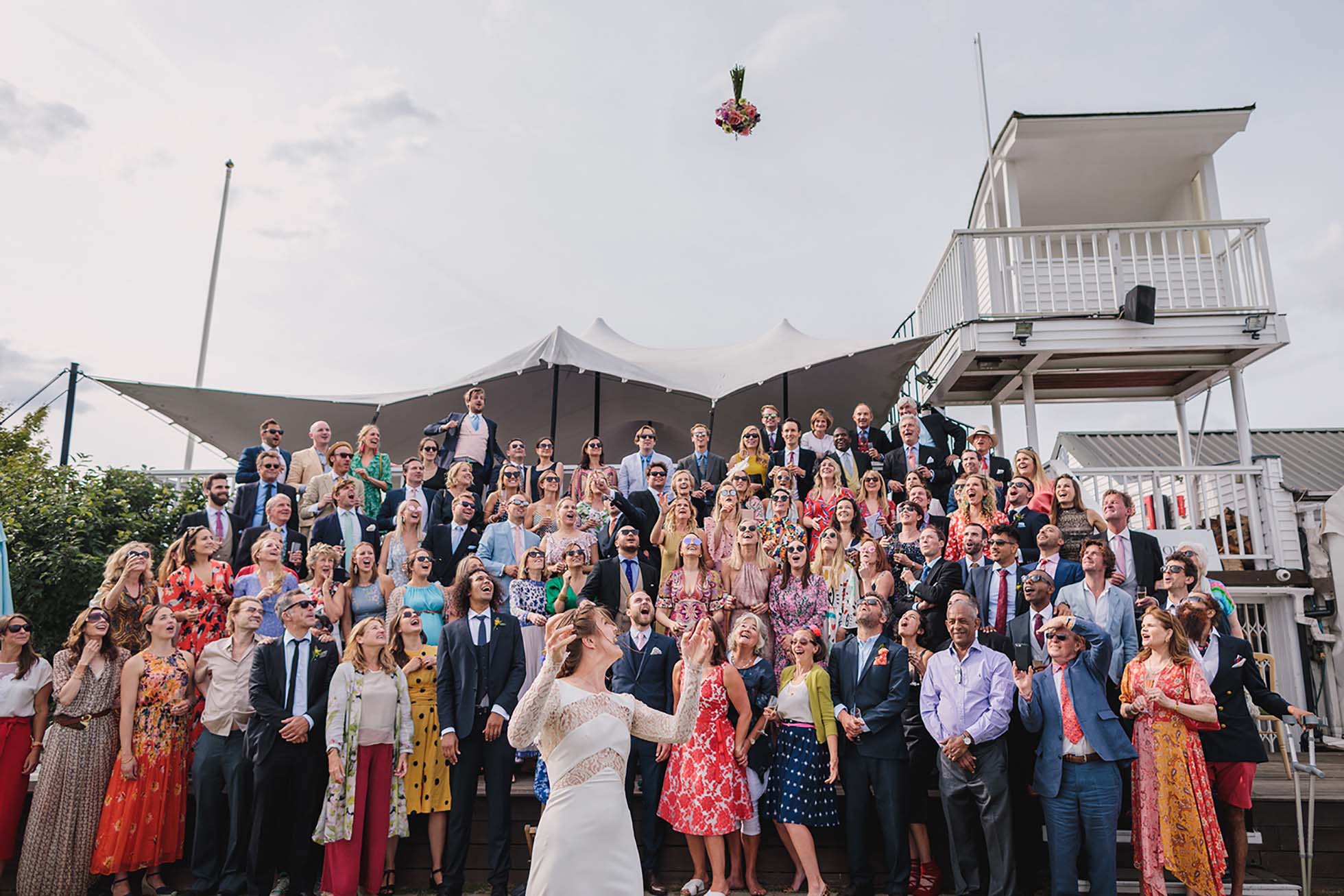 Bouquet toss to all the wedding guests at Ham Polo Club