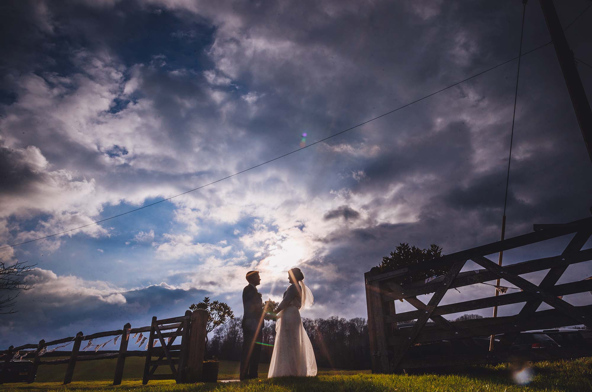 Bride and groom silhouette portrait under moody sky at Bartholomew Barn
