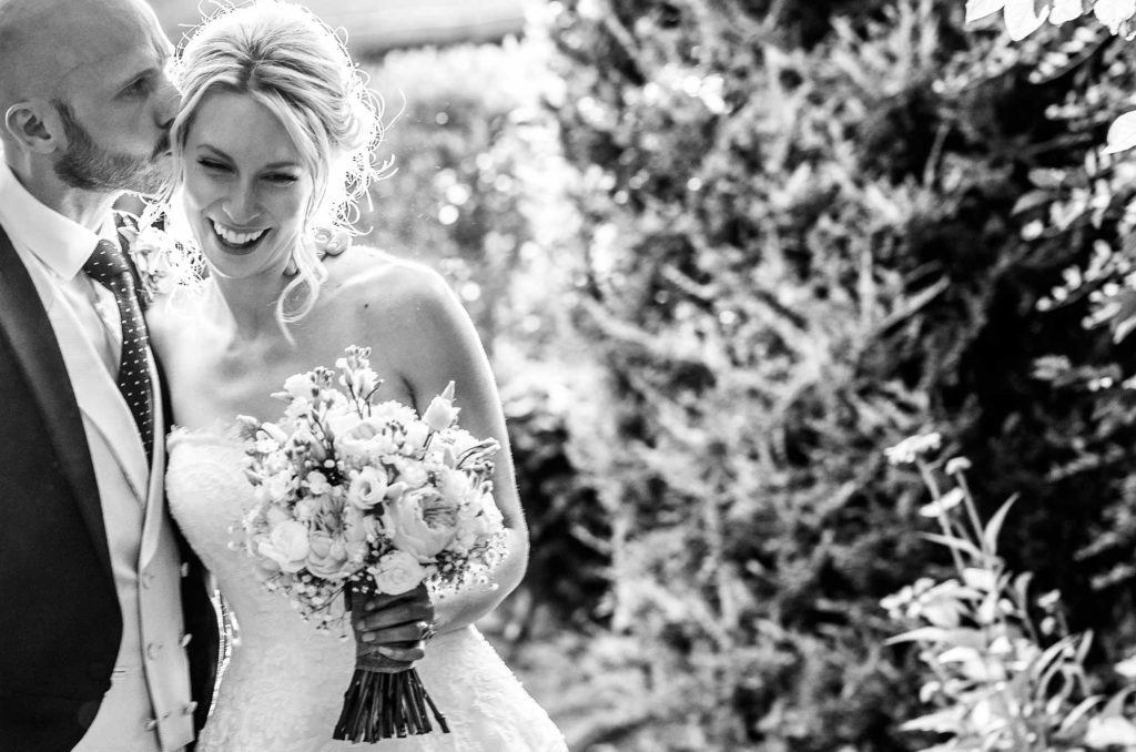 Groom kisses the temple of his beautiful bride 