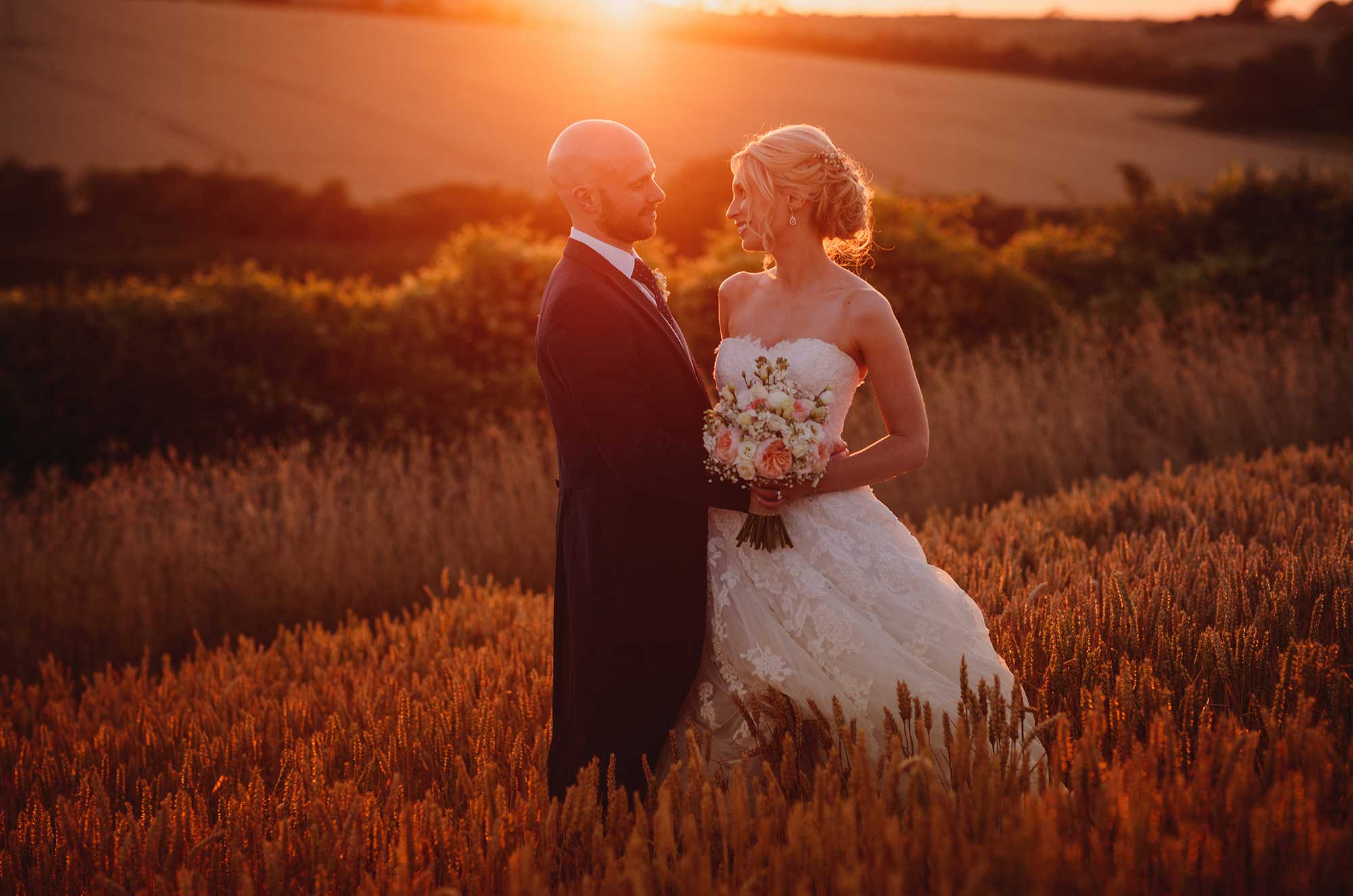 Bride and groom golden hour portrait in wheat fields at Pangdean Barn