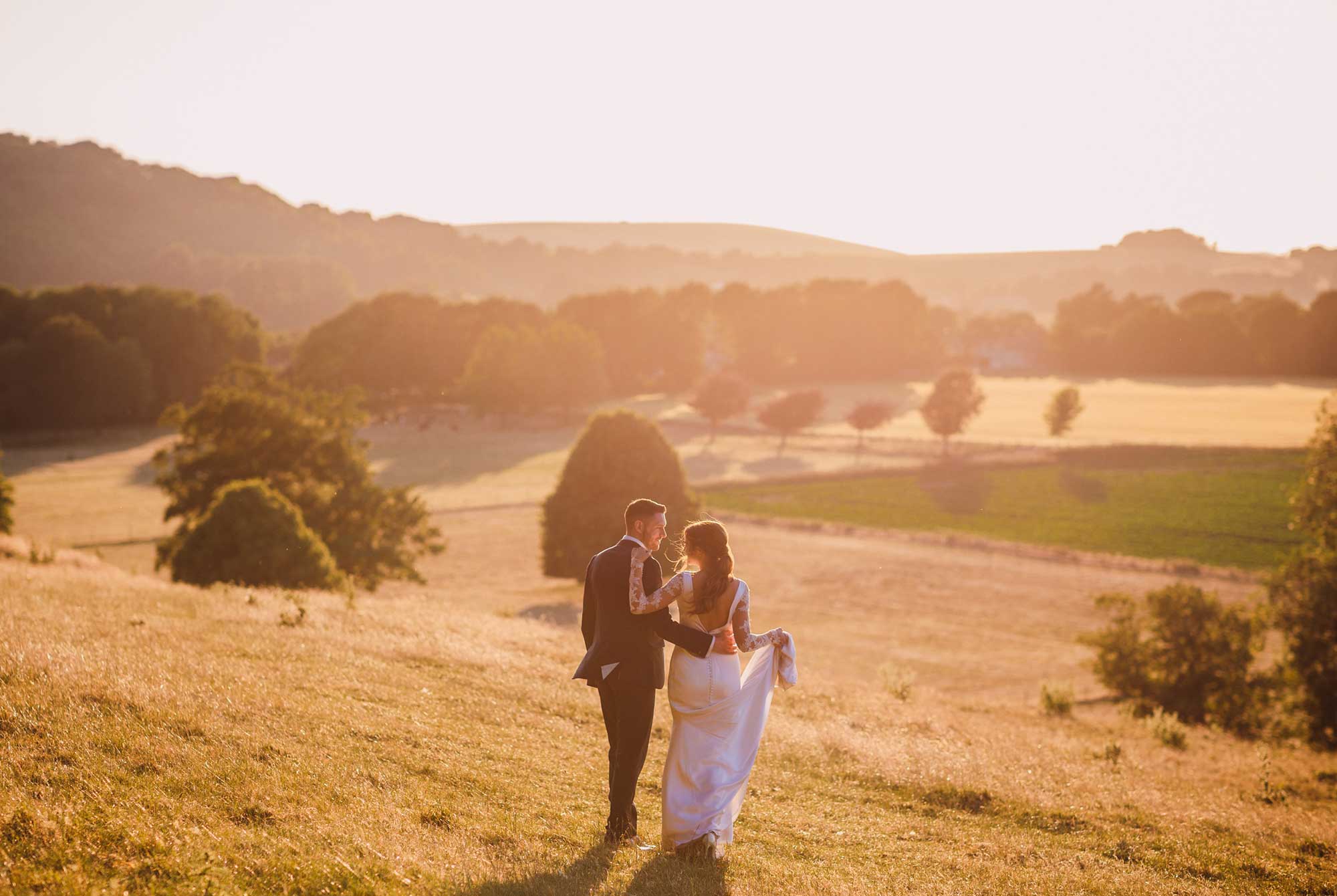 Bride and groom overlooking fields at Cissbury Barns