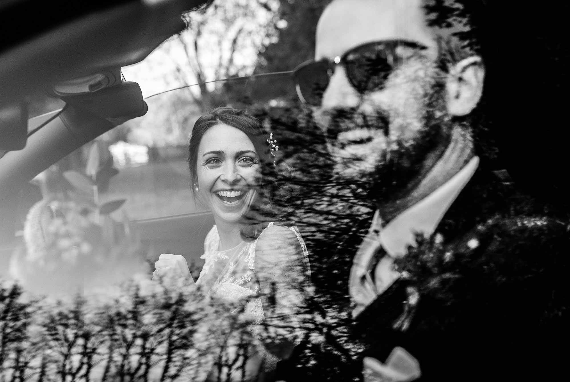 Bride and groom laughing in their car as they depart from St Mary's House in Bramber 