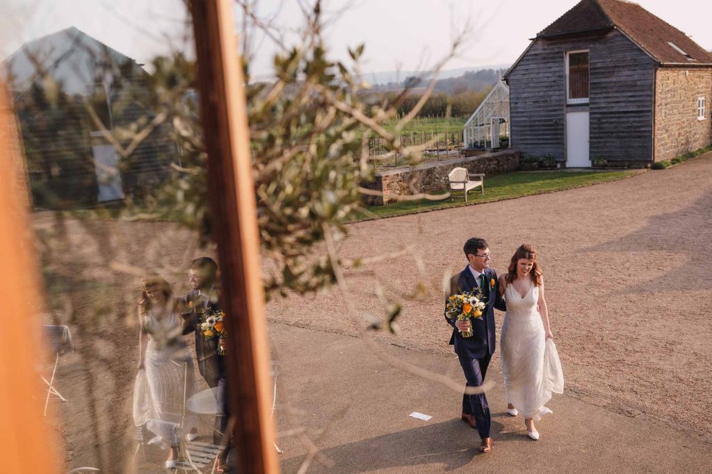 Bride and groom make their way to the wedding breakfast at Grittenham Barn