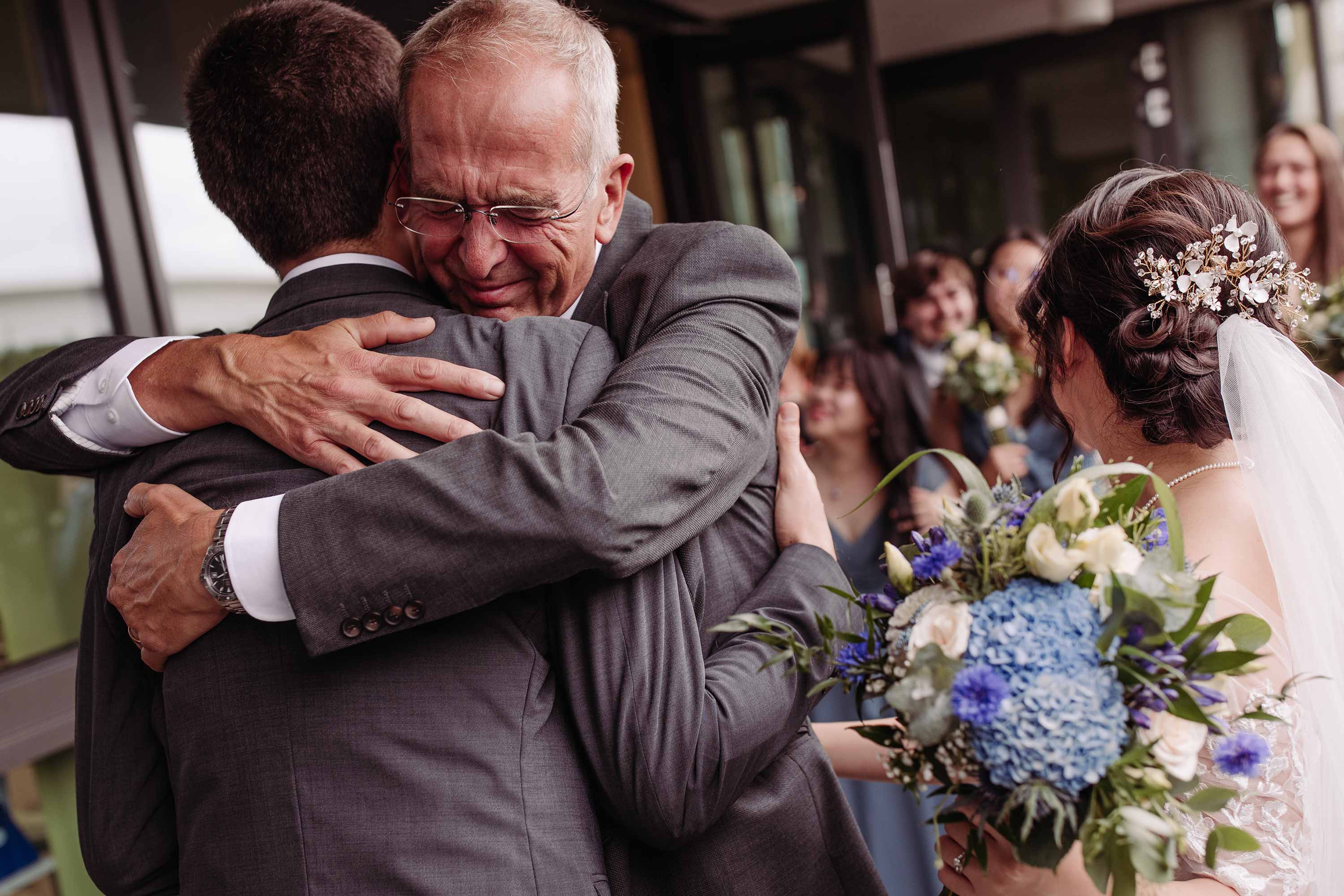 Intense hug from between the groom and the father of the groom at Crawley registry office