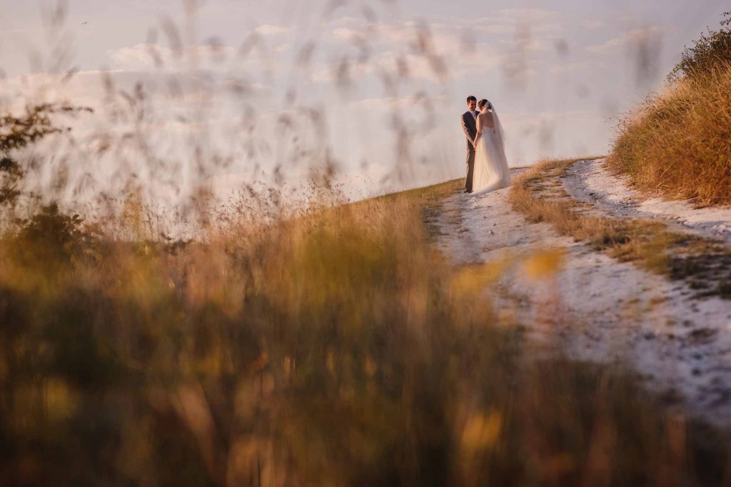 Bride and groom stop for a moment on the chalk path on the South Downs