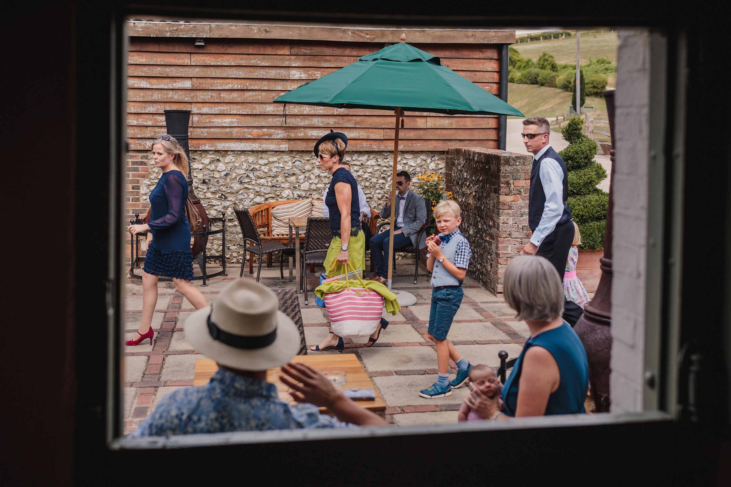 people arriving at Pangdean Barn wedding framed in the dairy window