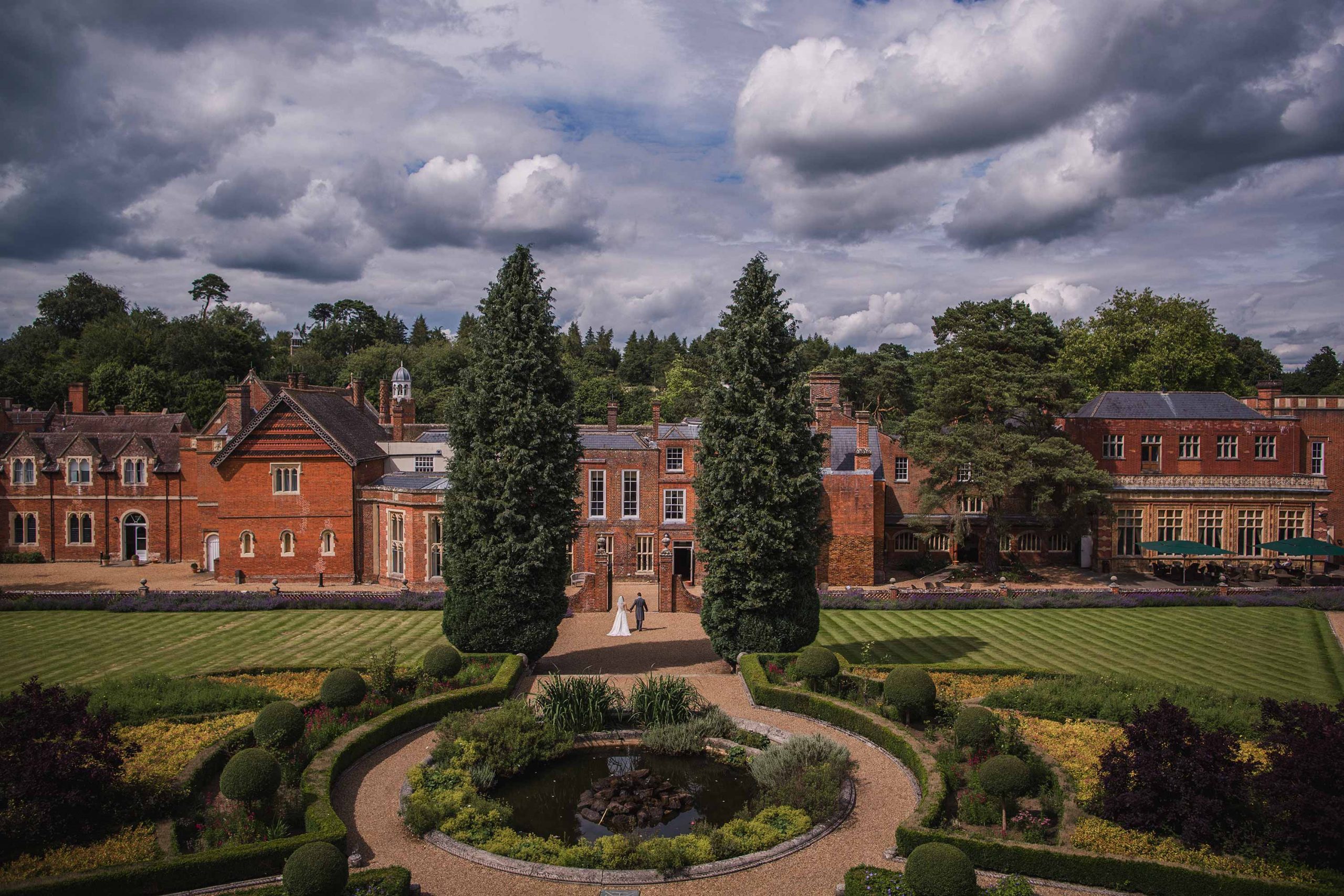 Bride and groom walking through the stunning Italian Gardens at Wotton House in Surrey
