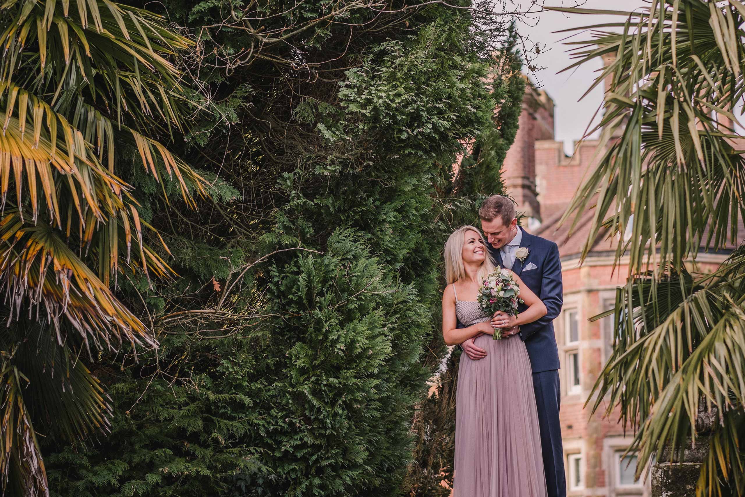 Bride and groom embrace in the gardens at Alexander House Hotel and Spa