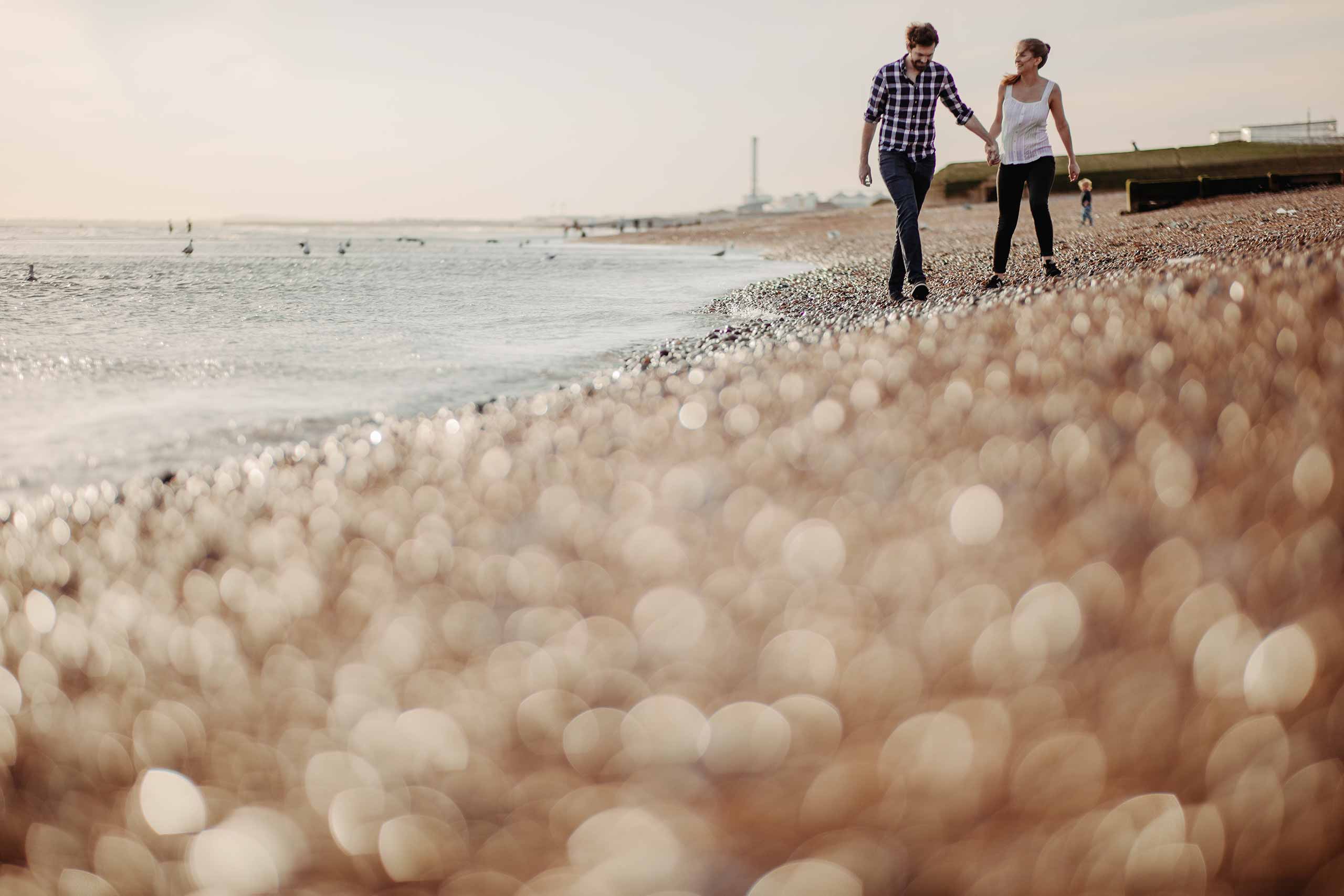 Couple walking on Hove beach during their pre-wedding shoot