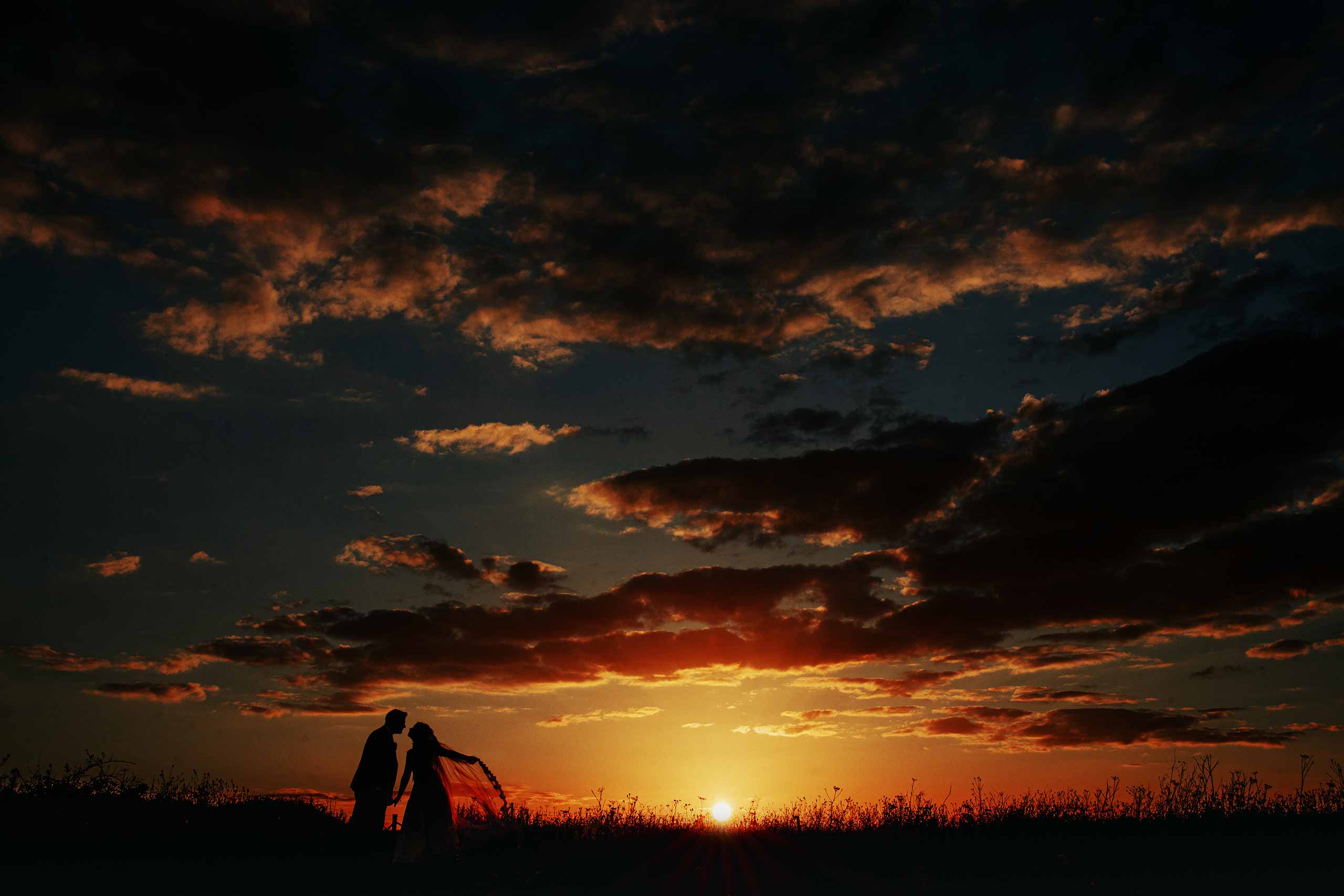 Sunset on the Ditchling Beacon with silhouette of bride and groom