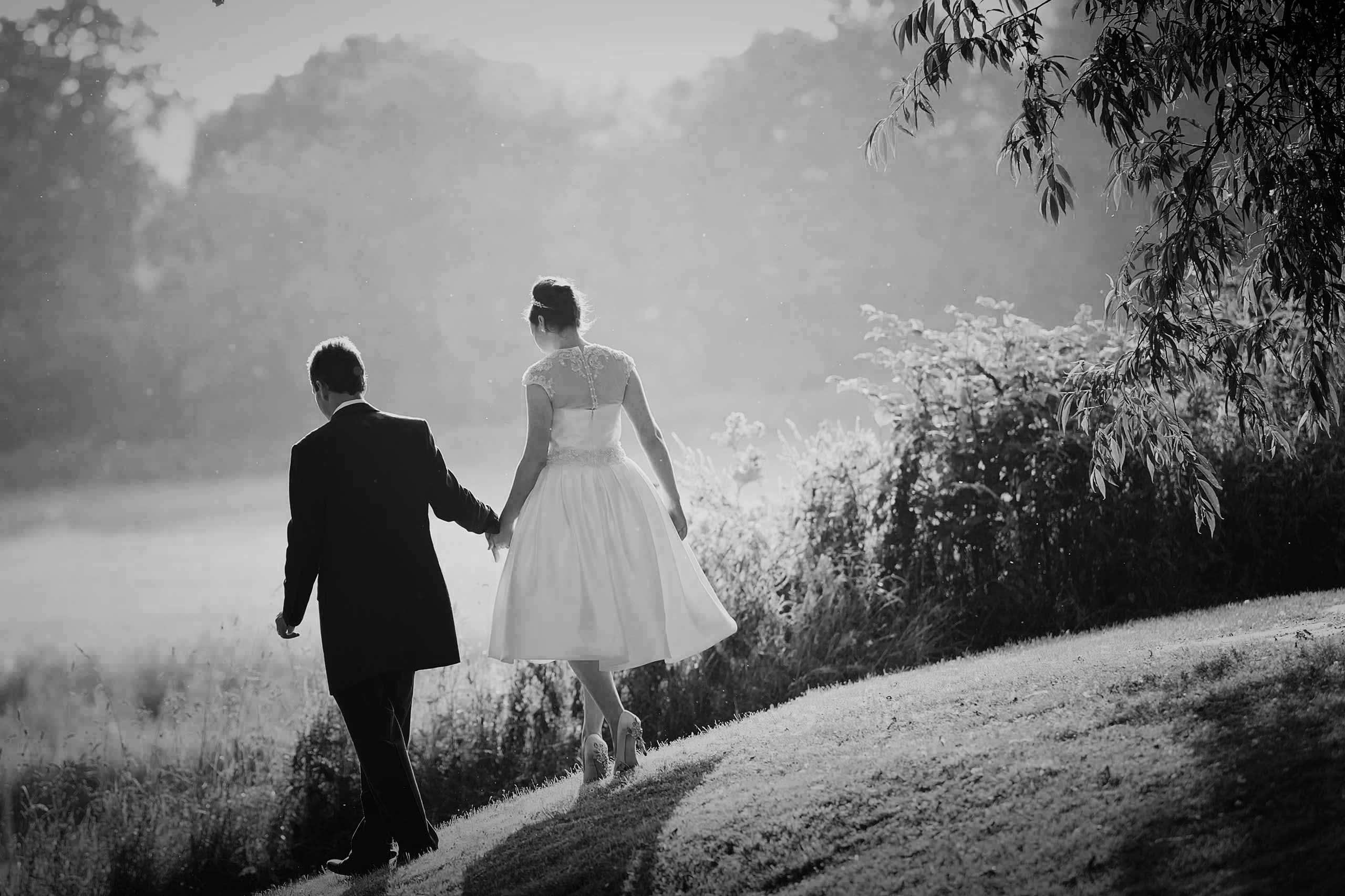 50's bride and groom walking hand in hand at their coltsford mill wedding