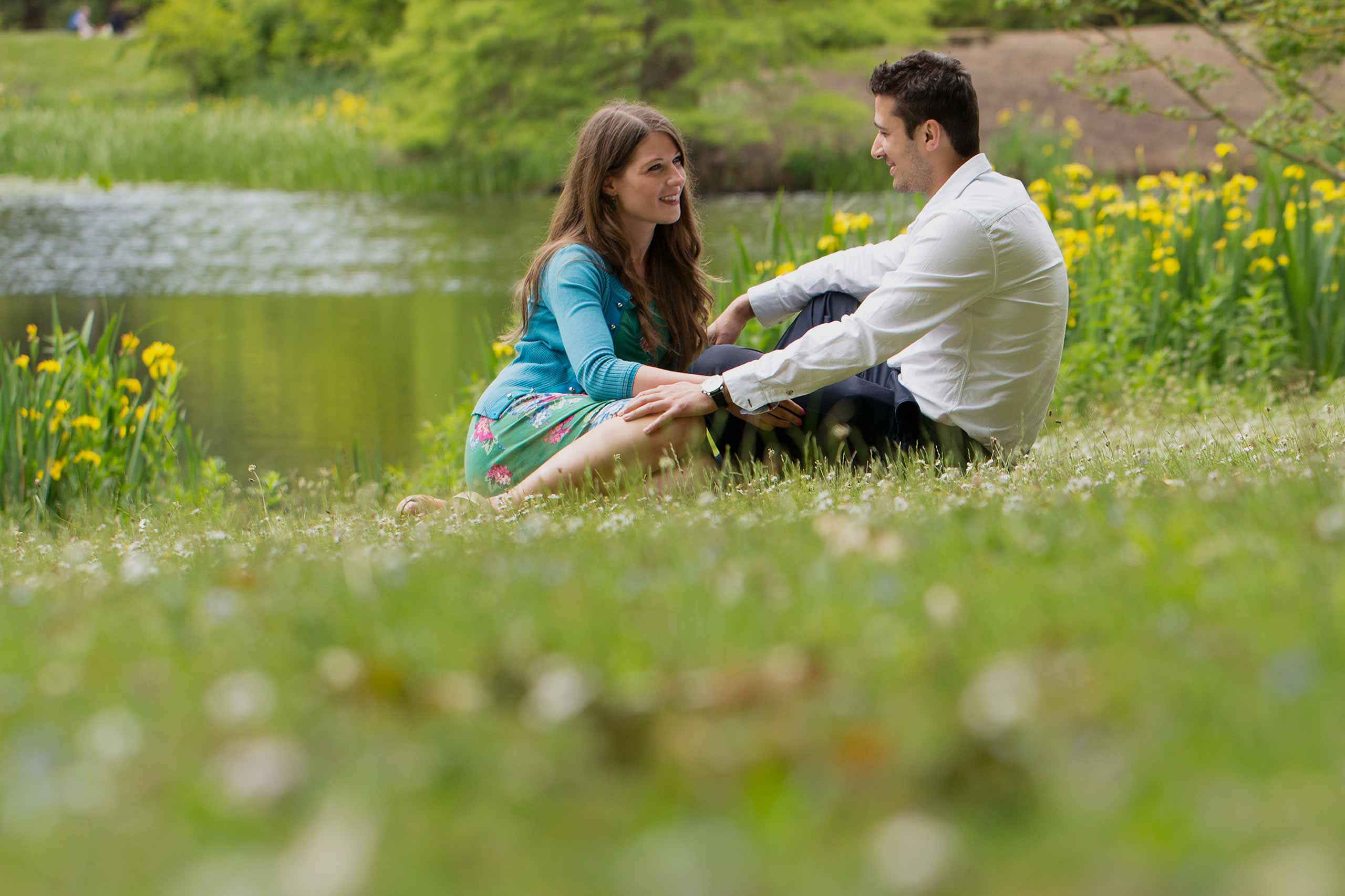 Couple sitting in the grass together during their Kew Gardens engagement shoot