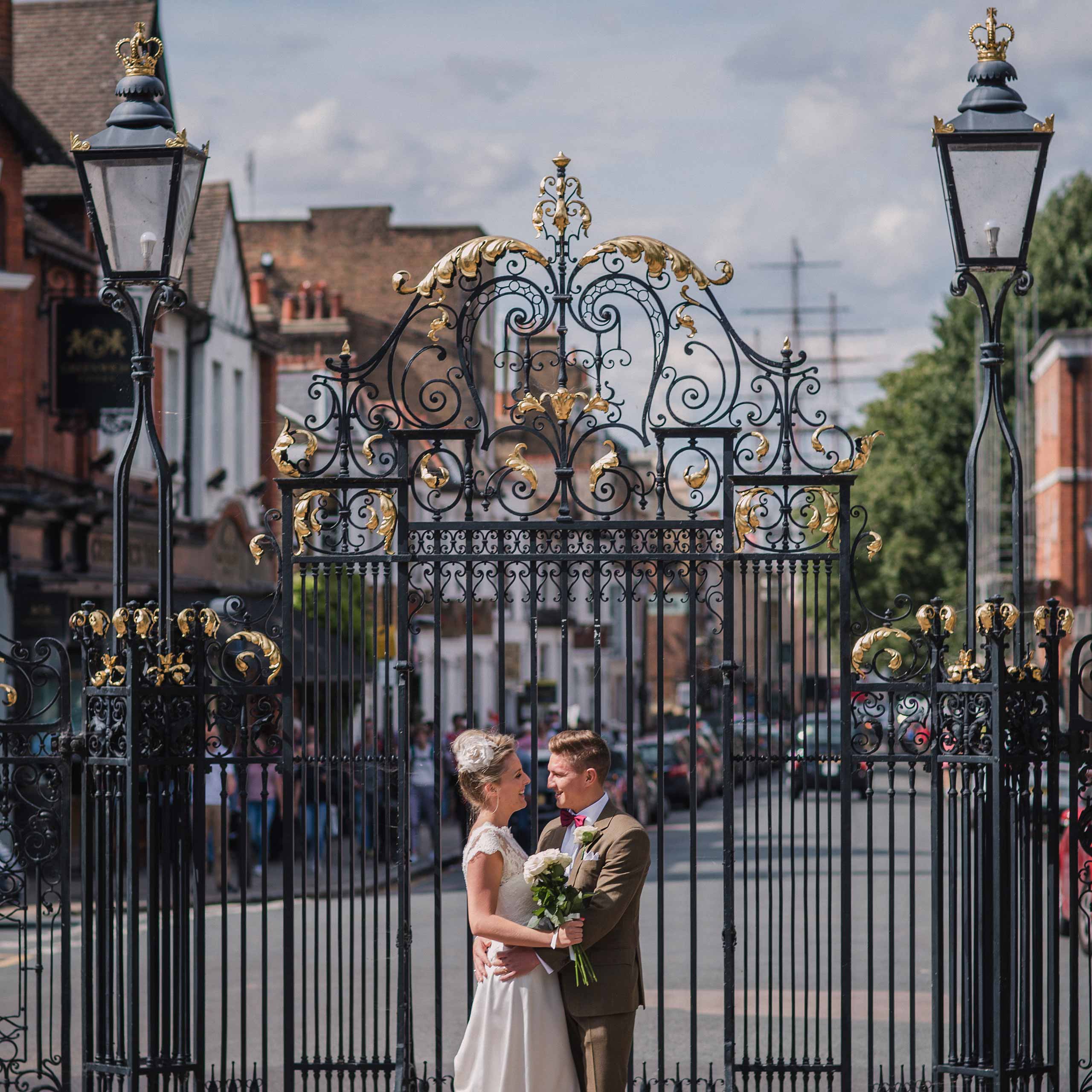 Bride and Groom embrace at the gates of Greenwich Park
