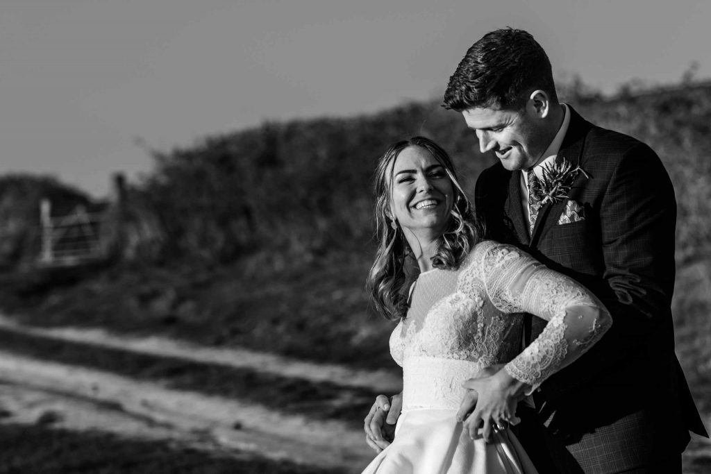 Black and white shot of bride and groom with strong side lighting