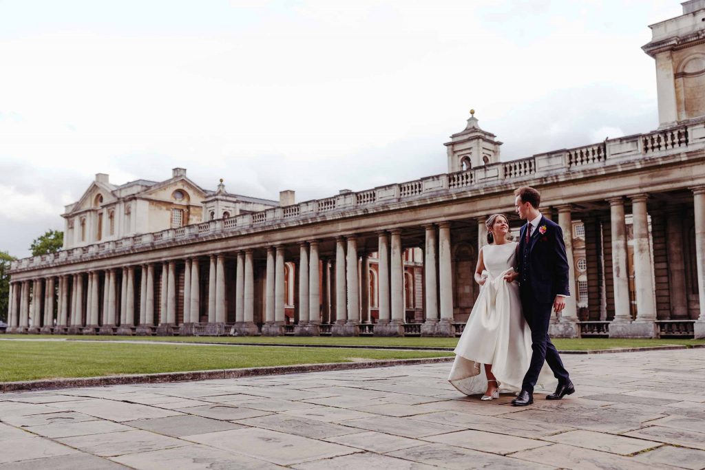Bride and groom walking through the Greenwich Naval College
