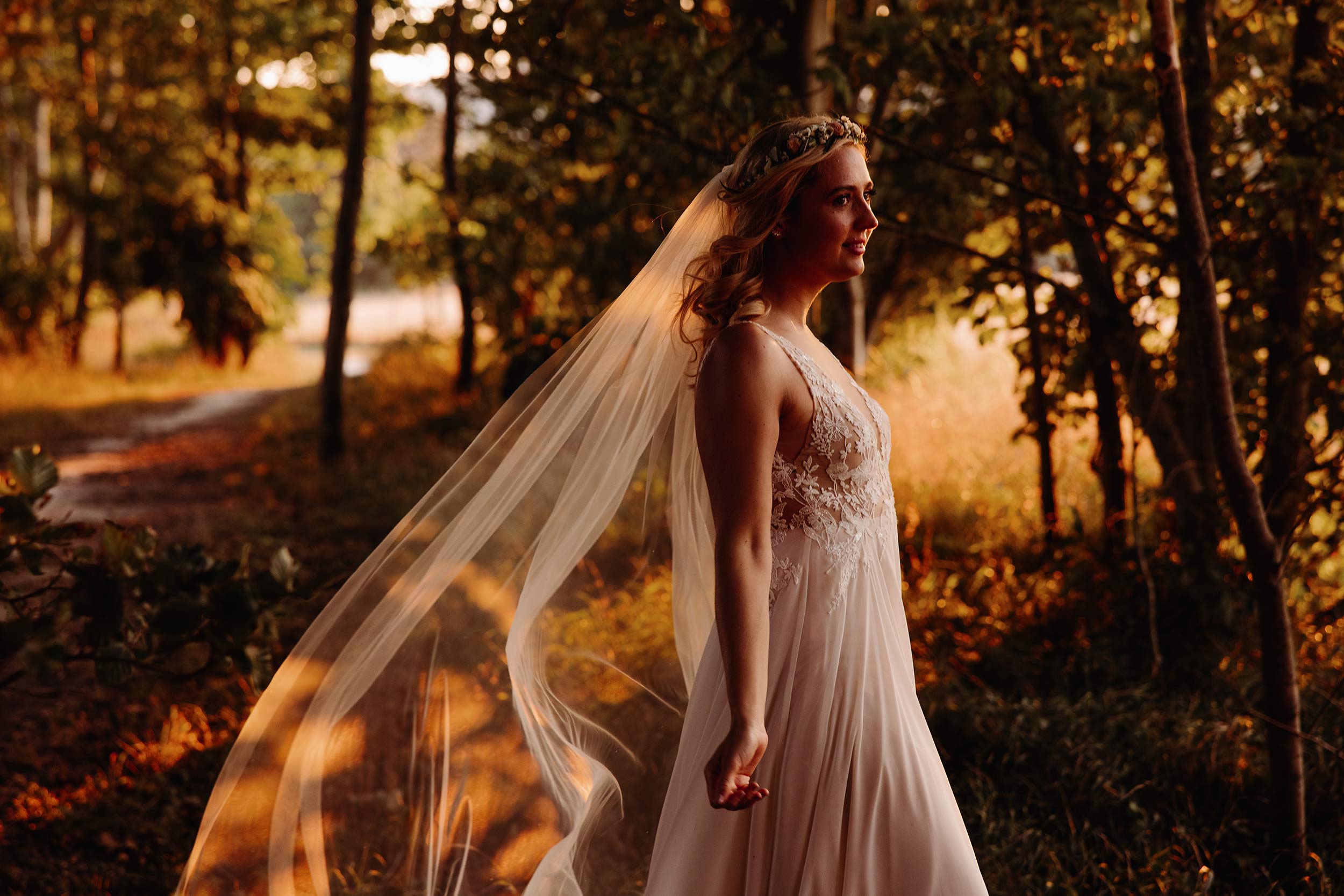 Bride in a woodland at Cissbury Barns at golden hour