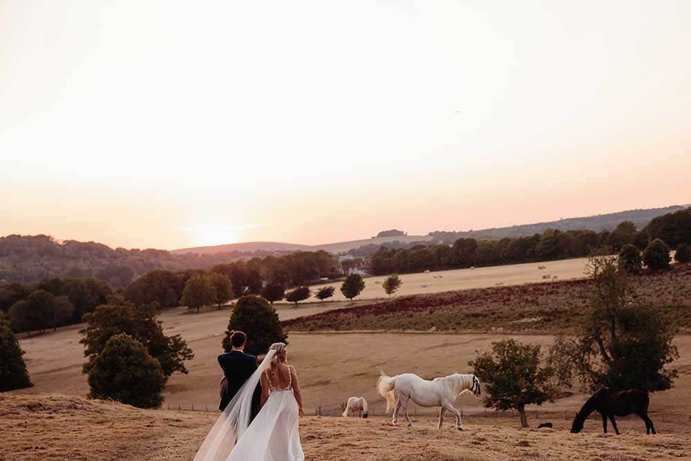 Bride and groom golden hour over the valley at Cissbury Barns 