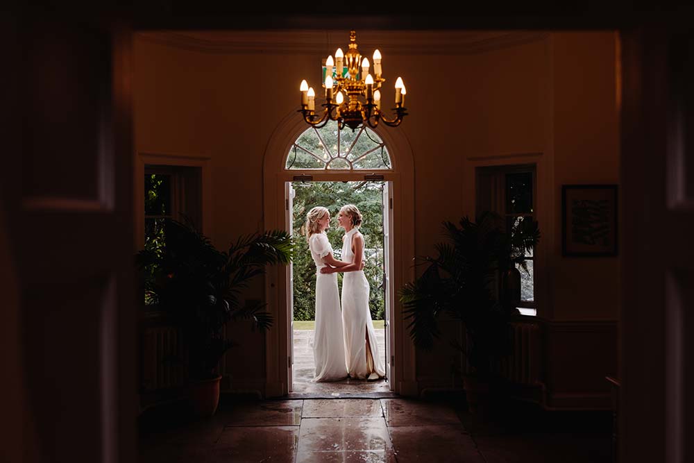 Two bride's embrace in the doorway after their same sex Pelham House wedding ceremony