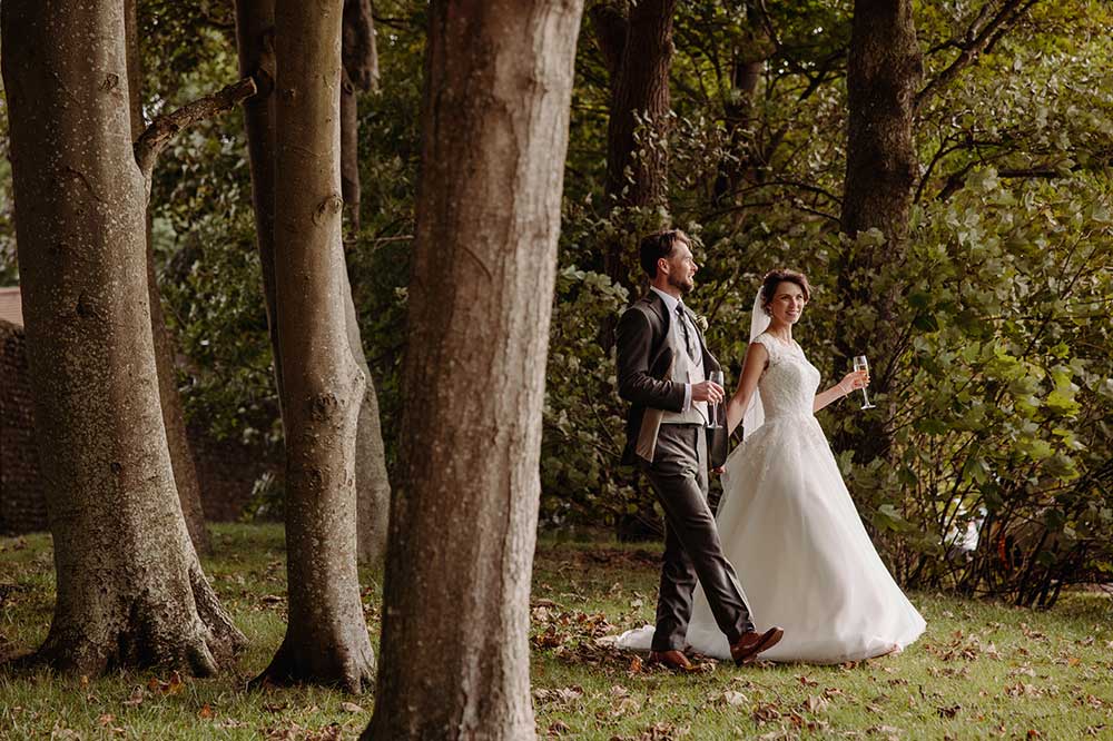 Bride and Groom walk I’m outside of the tress at their Cissbury Barns wedding