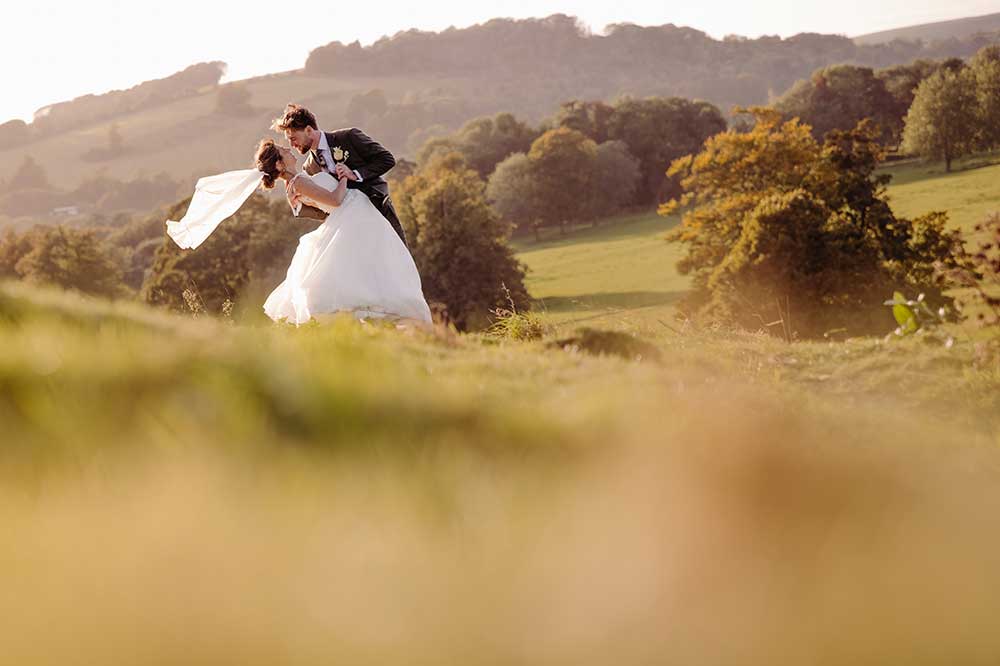 Bride and groom dip in the South Downs landscape