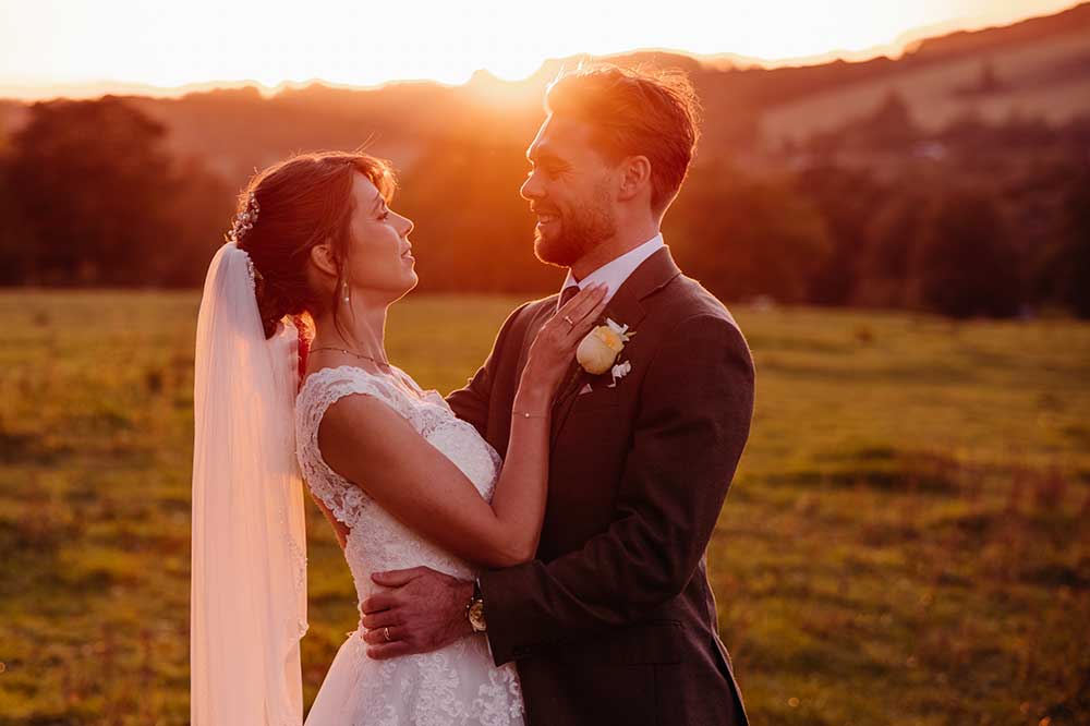 bride and groom embrace at golden hour on the South Downs.
