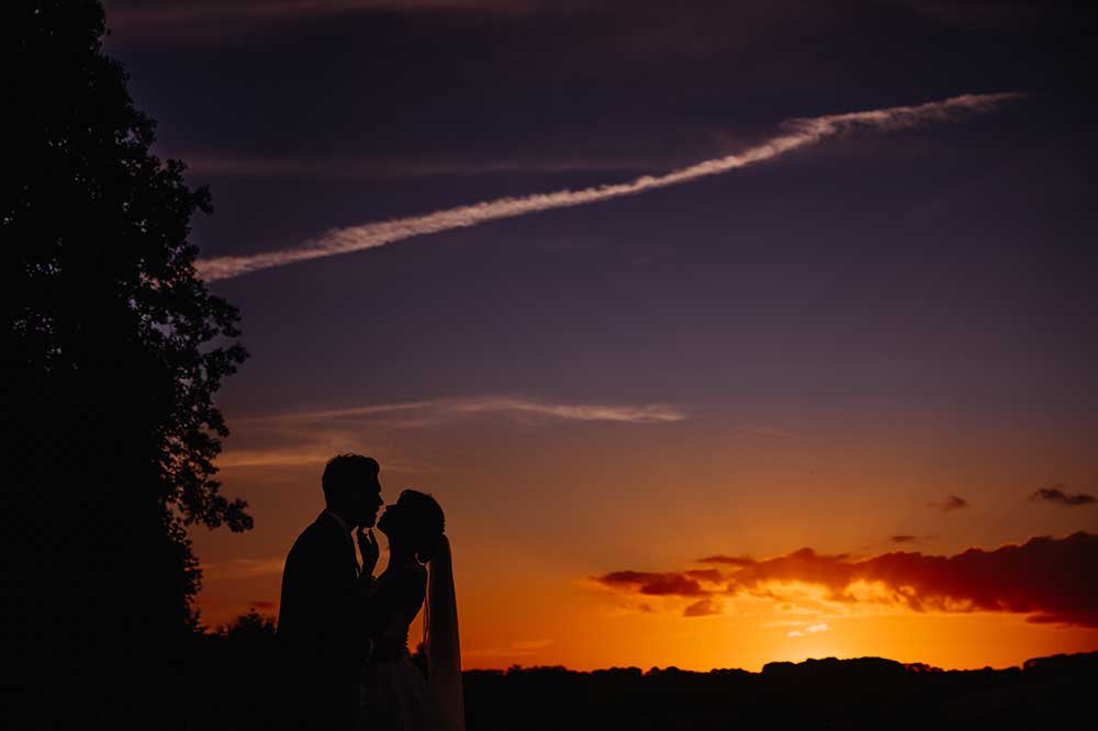 Bride and groom at sunset on the South Downs at Cissbury Barns