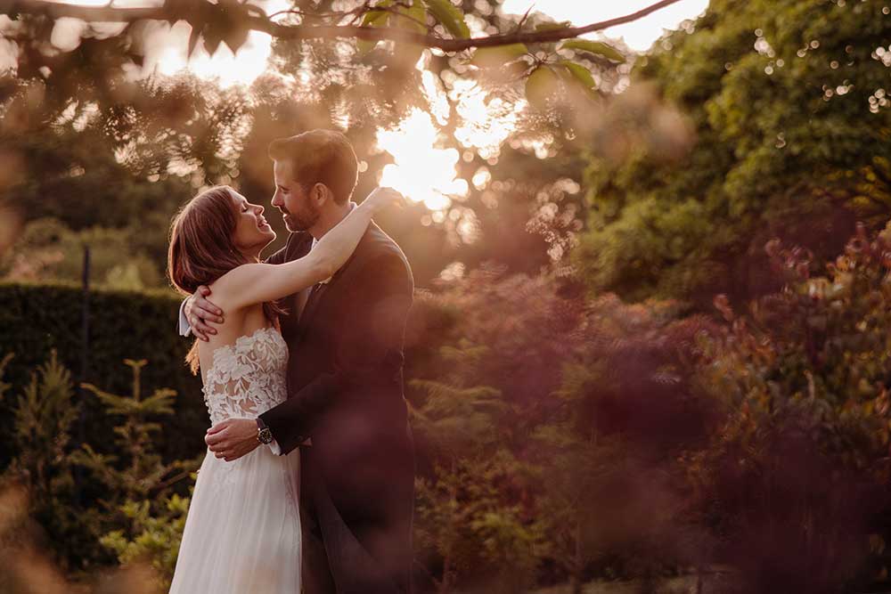Bride and groom embrace in the garden of Wadhurst Castle