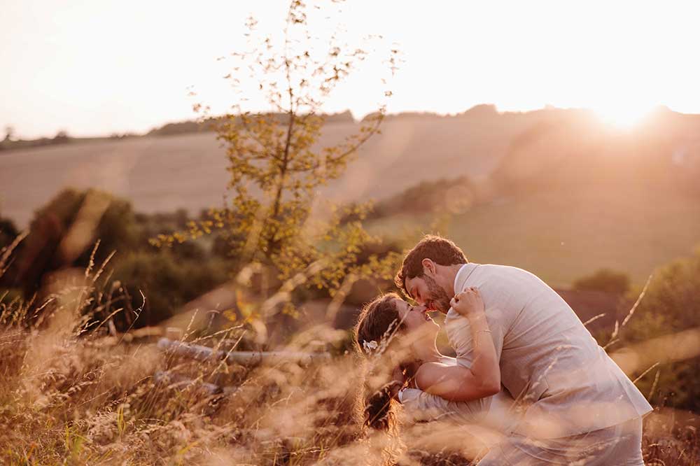 Golden hour wedding couple dip on the South Downs at Upwaltham Barns